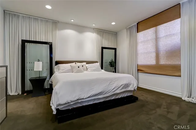 a bedroom with a bed and large window