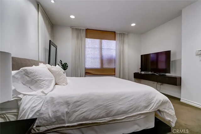 a bedroom with a bed and a flat screen tv