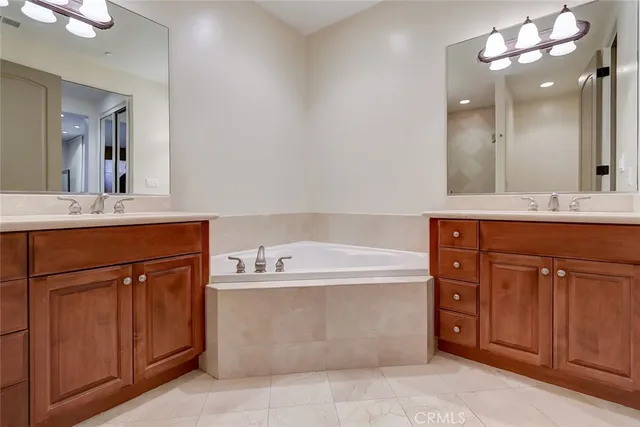 a spacious bathroom with a tub sink and mirror