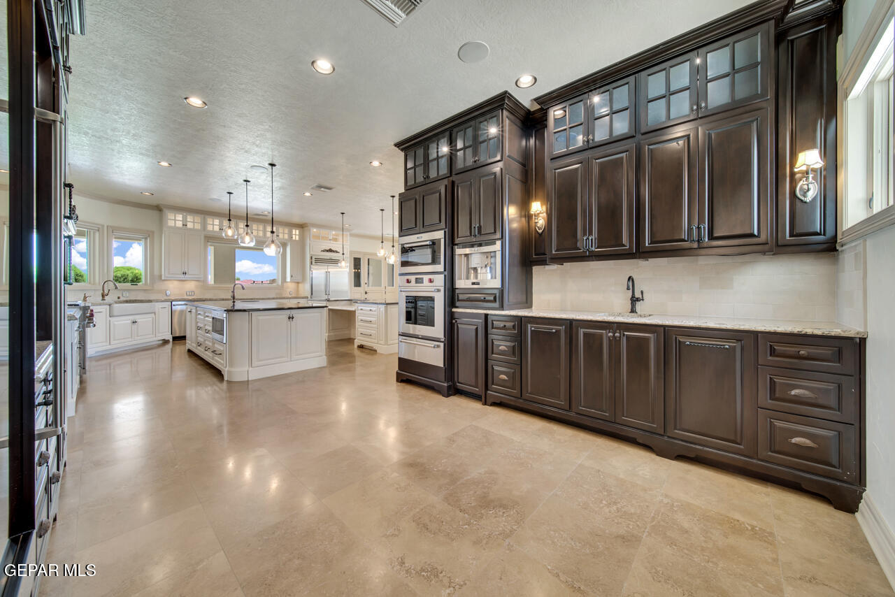 7 Cielo Del Este Anthony, NM 88021 - Photo 45 of 95 a kitchen with stainless steel appliances kitchen island granite countertop a refrigerator oven a sink dishwasher and white cabinets with wooden floor