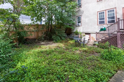 a backyard of a house with table and chairs
