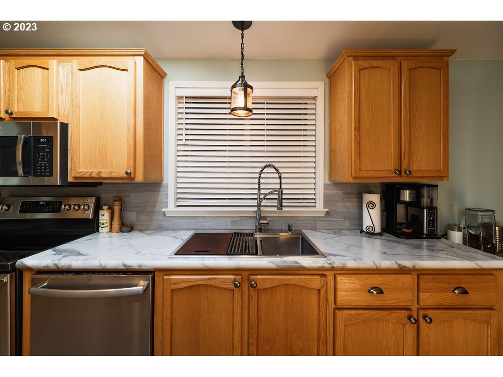 369 Gun Club Road, Unit 16 Woodland, WA 98674 - Photo 14 of 44 a kitchen with stainless steel appliances granite countertop a sink a stove and a microwave