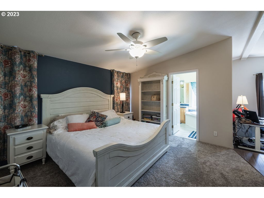 369 Gun Club Road, Unit 16 Woodland, WA 98674 - Photo 16 of 44 a bedroom with a bed and a chandelier