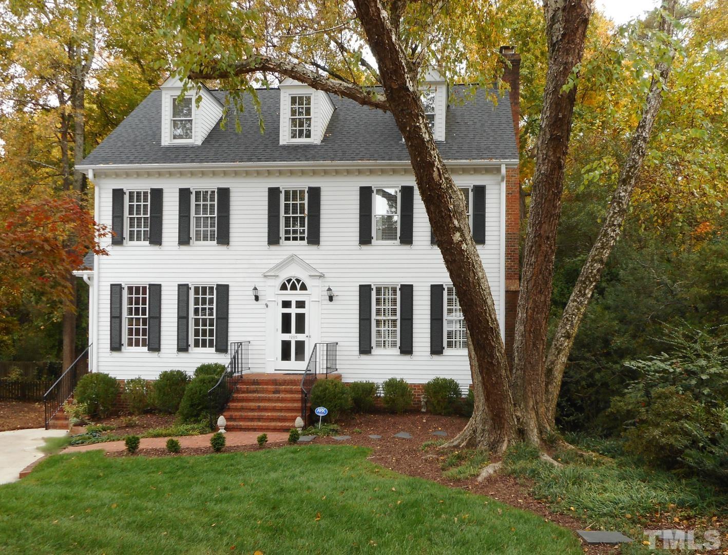 1205 Weldon Place Raleigh, NC 27608 - Photo 1 of 33 a front view of a house with a garden and trees