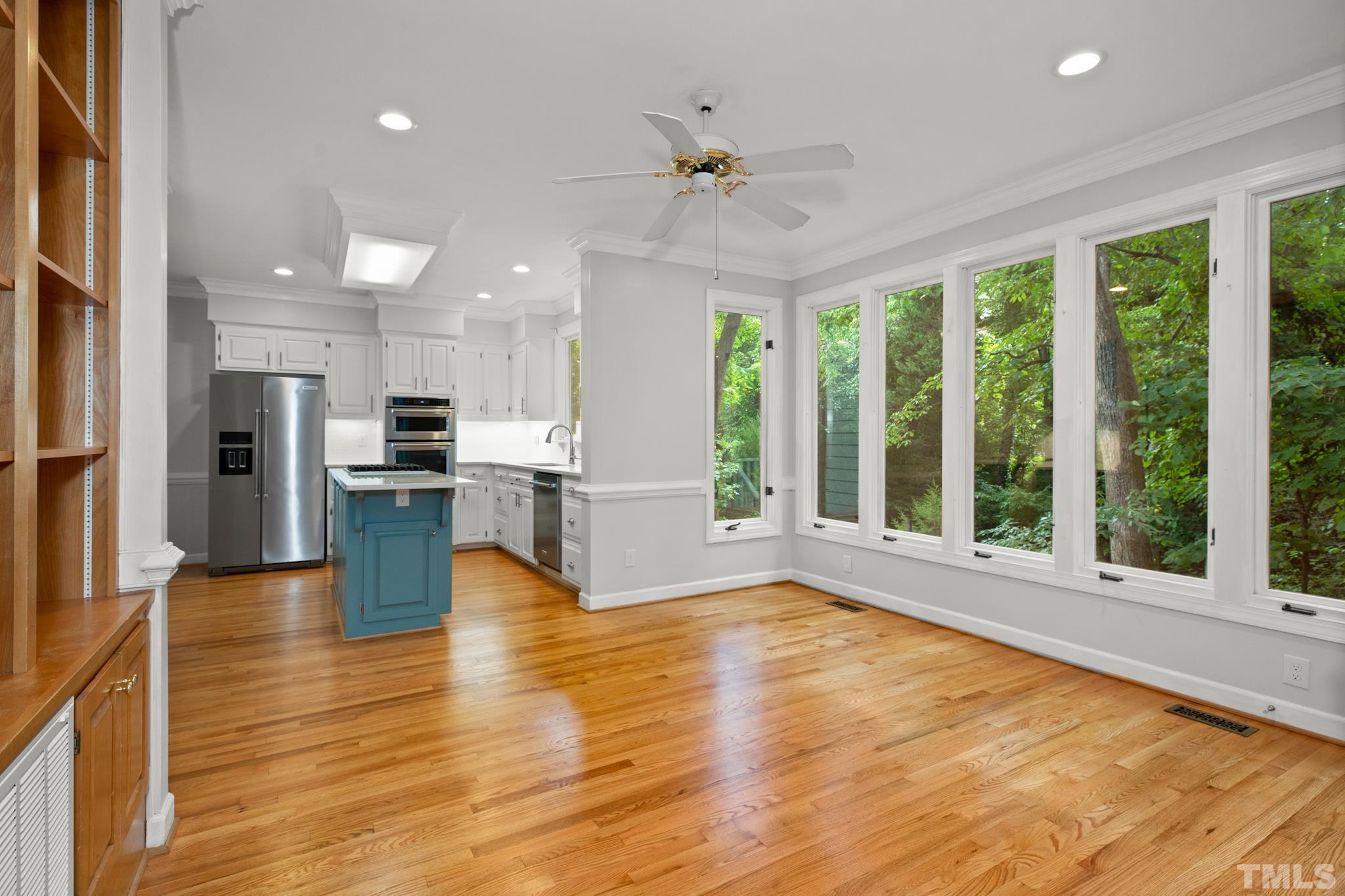 1205 Weldon Place Raleigh, NC 27608 - Photo 18 of 33 a view of an empty room with wooden floor and a kitchen