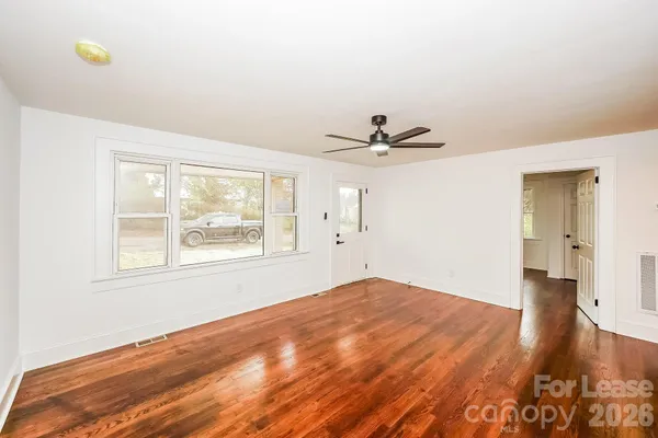 a view of a big room with wooden floor and a window