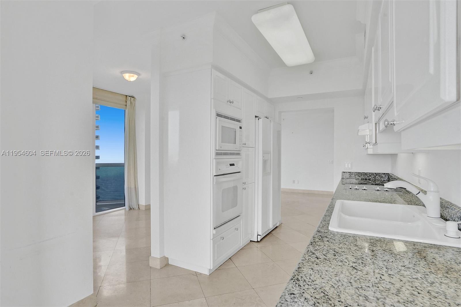 4775 Collins Avenue, Unit 3007 Miami Beach, FL 33140 - Photo 26 of 60 a living room with white furniture and a rug