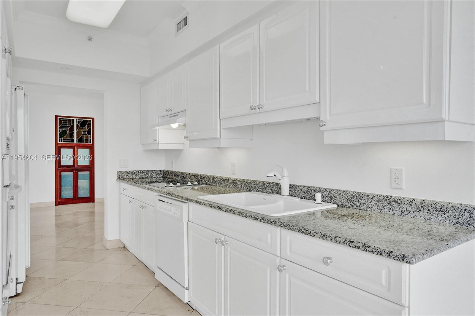 4775 Collins Avenue, Unit 3007 Miami Beach, FL 33140 - Photo 27 of 60 a kitchen with granite countertop a sink and cabinets