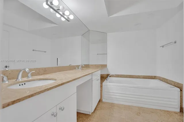 a en suite bathroom with a granite countertop sink and a mirror