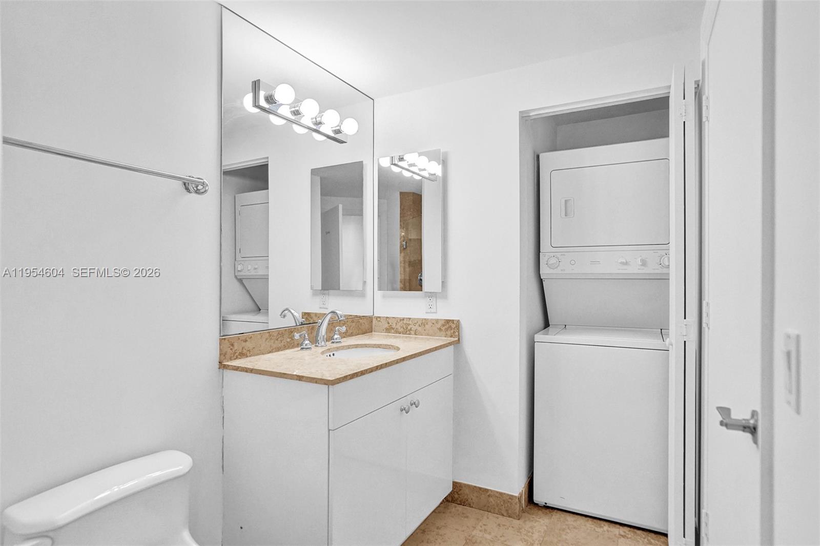 4775 Collins Avenue, Unit 3007 Miami Beach, FL 33140 - Photo 39 of 60 a en suite bathroom with a granite countertop sink and a mirror