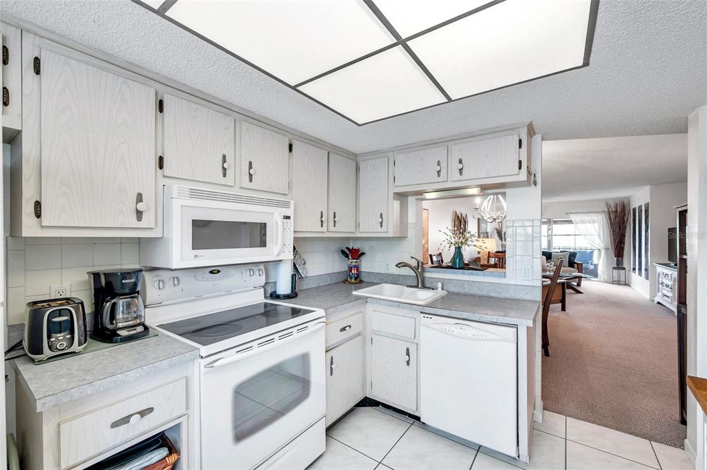 1430 Heather Ridge Boulevard, Unit 304 Dunedin, FL 34698 - Photo 8 of 36 a kitchen with cabinets appliances a sink and a counter top space