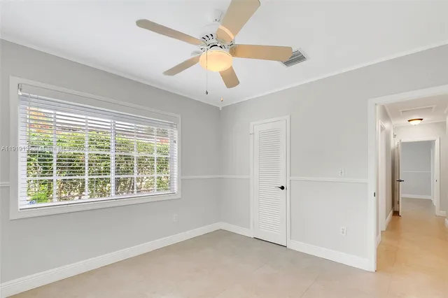 an empty room with fan and windows