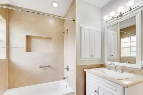 a bathroom with a sink tub vanity and a mirror