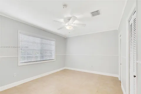 an empty room with a window and a fan