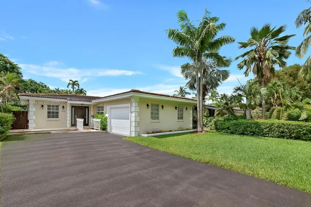 a front view of house with yard and tree in it
