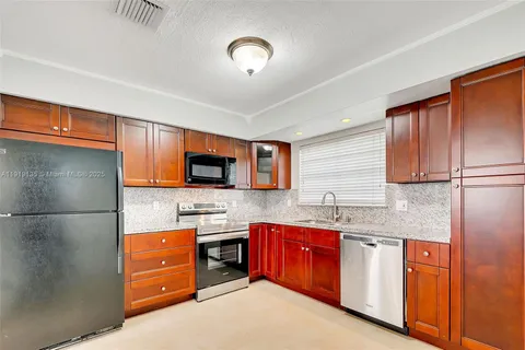 a kitchen with granite countertop a sink stainless steel appliances and cabinets
