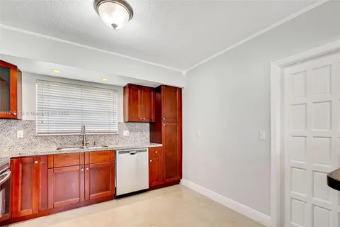 a kitchen with granite countertop a sink and cabinets
