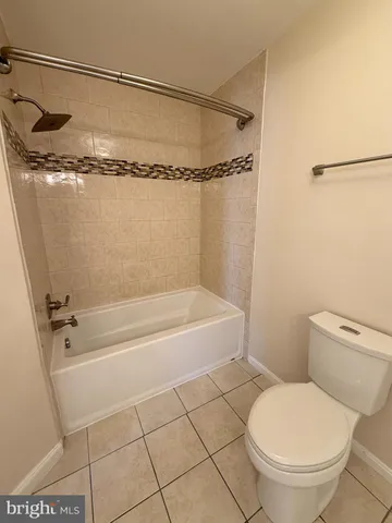 a bathroom with a granite countertop bathtub shower and toilet