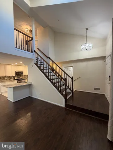 a kitchen with granite countertop a stove a chimney and a wooden floor