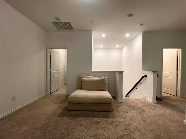 a living room with furniture a air conditioner vent and a flat screen tv