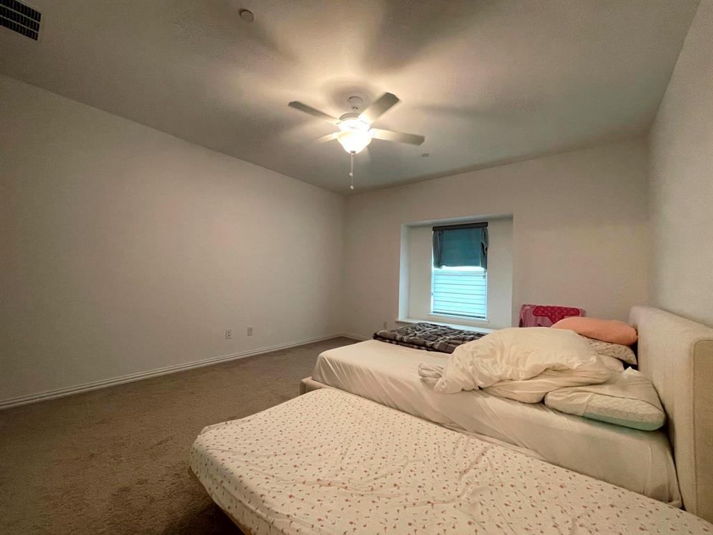 5514 Union Street Sachse, TX 75048 - Photo 15 of 25 a bedroom with a bed and a chandelier