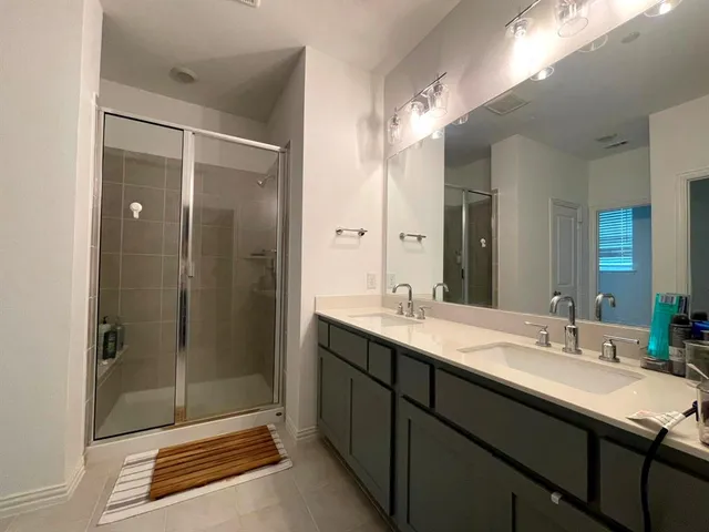 a bathroom with a granite countertop sink shower and a mirror