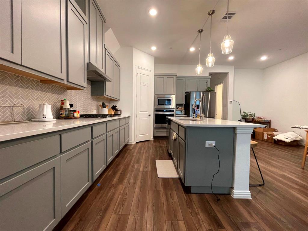 5514 Union Street Sachse, TX 75048 - Photo 6 of 25 a kitchen with kitchen island granite countertop a sink cabinets and wooden floor