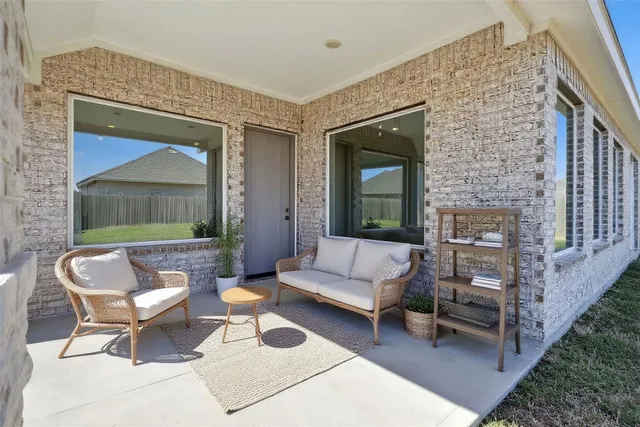 a view of a house next to a big yard with plants and large trees