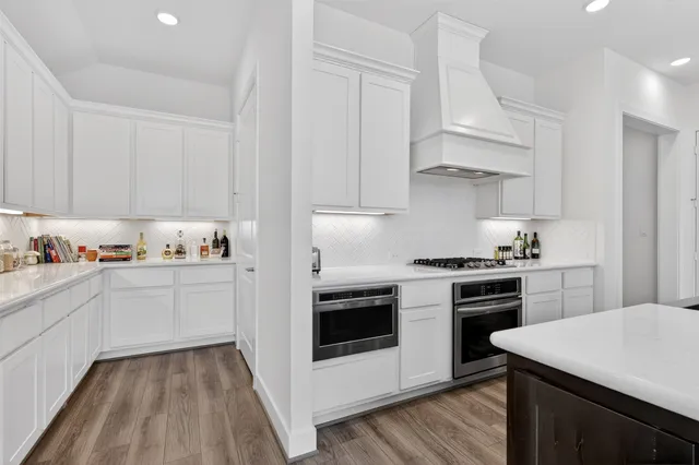 a kitchen with granite countertop white cabinets and white appliances