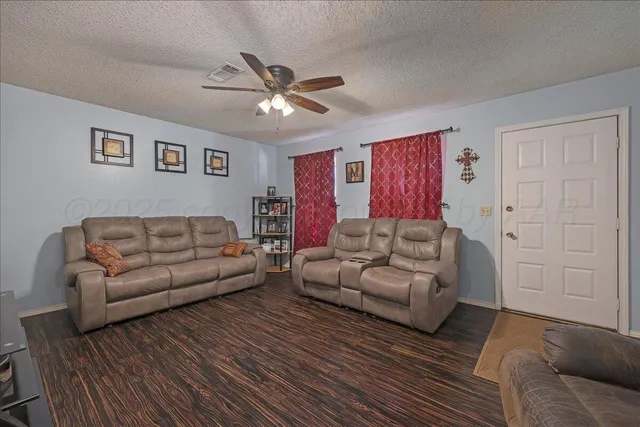 a living room with furniture and a ceiling fan