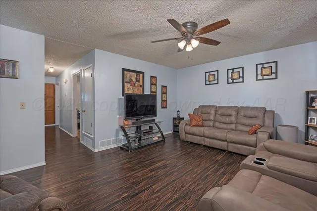 a living room with furniture and a flat screen tv with wooden floor