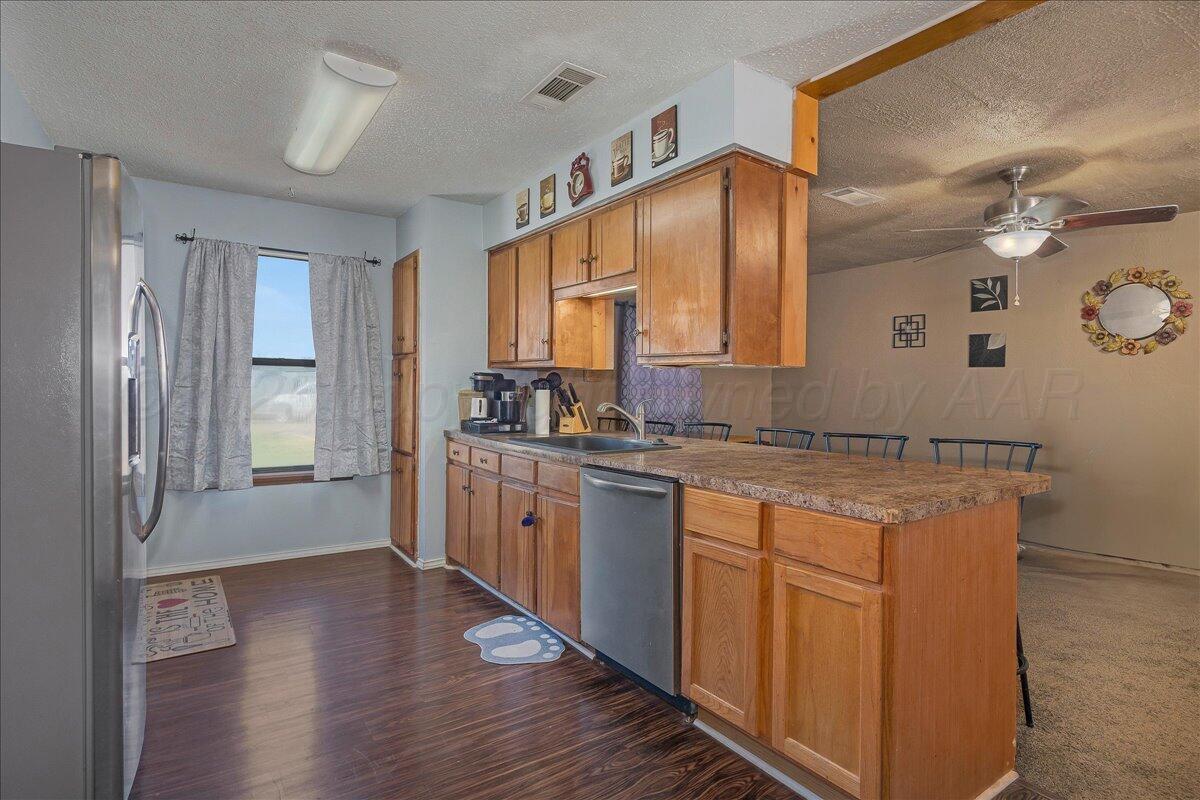 607 Groom Avenue Panhandle, TX 79068 - Photo 7 of 18 a kitchen with stainless steel appliances granite countertop a sink stove and wooden cabinets