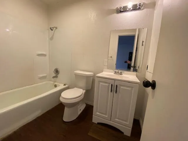 a white toilet sitting next to a bathroom sink and tub