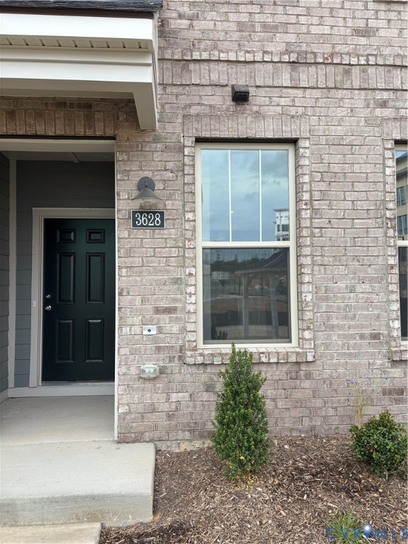 Brick facade featuring a panel door, decorative ou