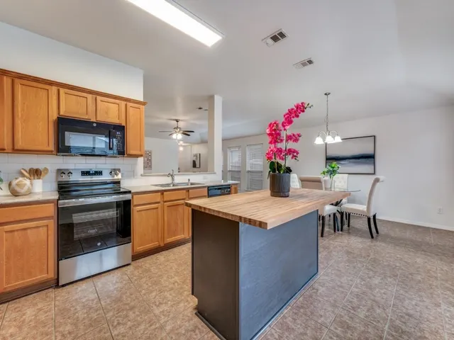 a kitchen with granite countertop a sink stove top oven and microwave