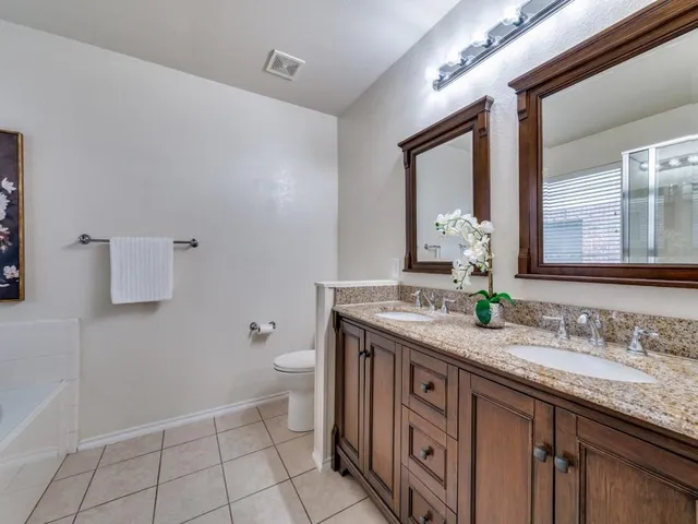 a spacious bathroom with a granite countertop sink and a mirror