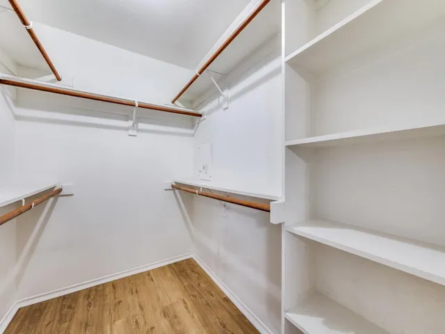 a view of walk in closet with empty racks