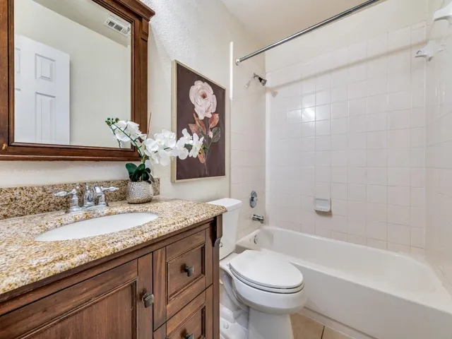 a bathroom with a granite countertop sink toilet and shower