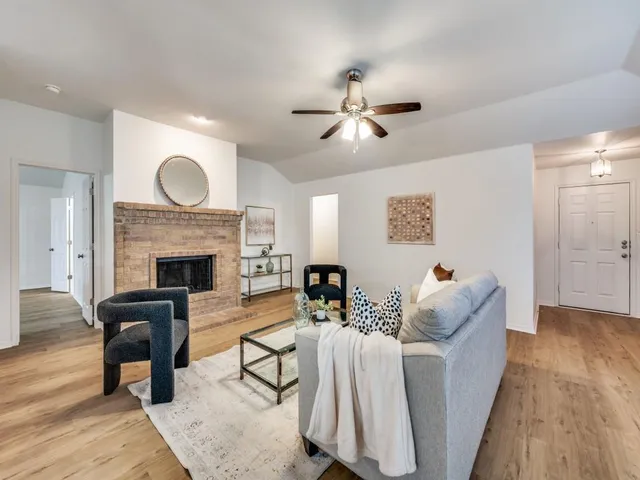 a living room with furniture a fireplace and a potted plant