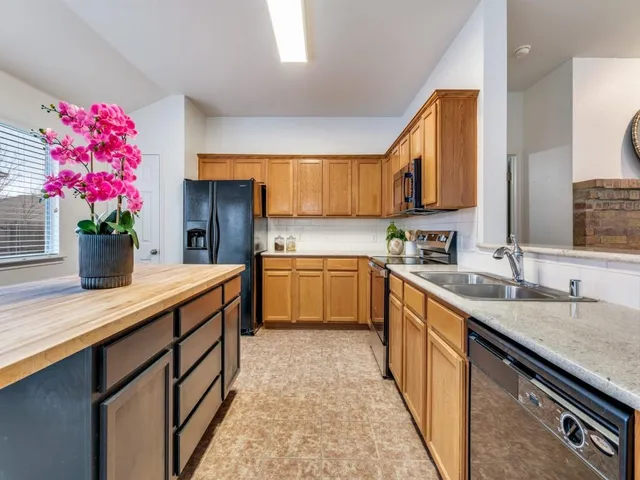 a kitchen with granite countertop a sink stove top oven and cabinets