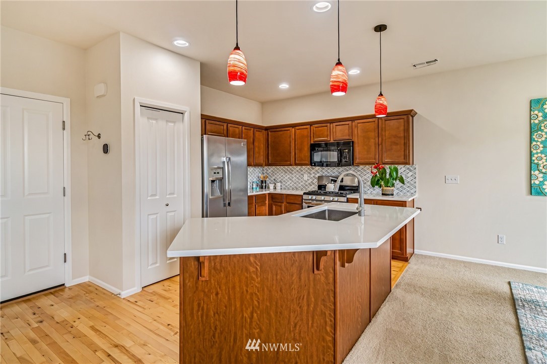 4114 167th Place Southeast Bothell, WA 98012 - Photo 13 of 38 a very nice looking open kitchen with stainless steel appliances granite countertop a stove a sink a refrigerator and a wooden floors