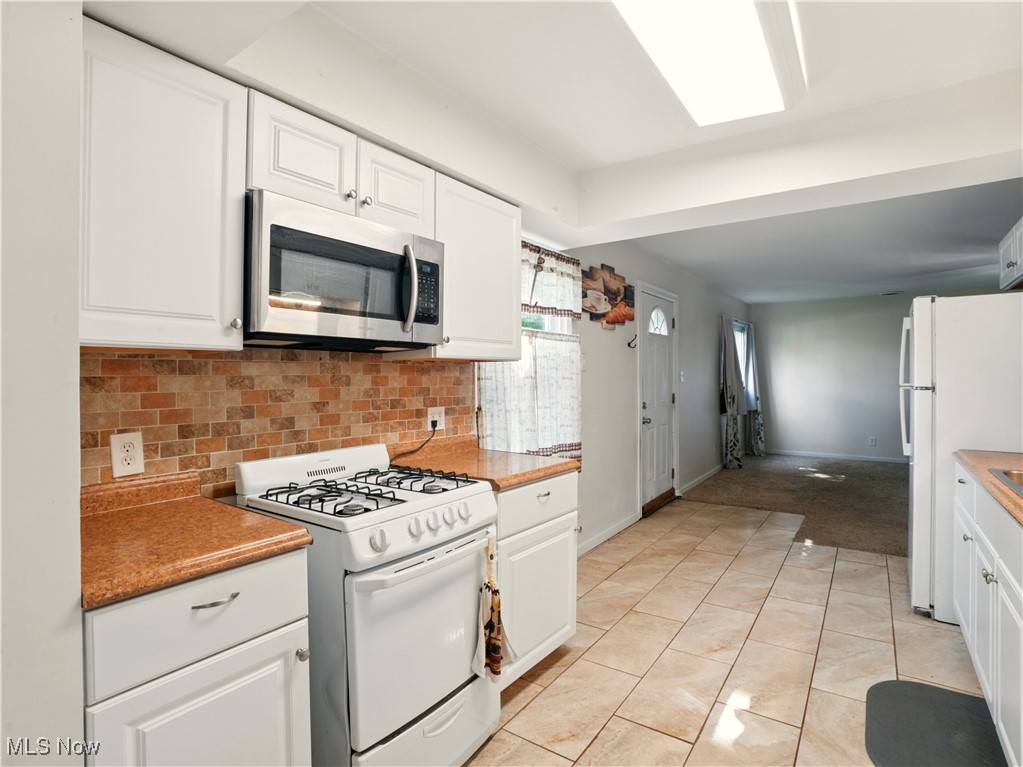 1942 Benjamin Road Madison, OH 44057 - Photo 7 of 29 Kitchen featuring white appliances and white cabinets