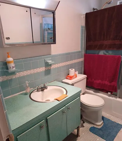 a bathroom with a sink a toilet and mirror