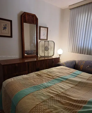 a bedroom with a bed and a mirror on dresser