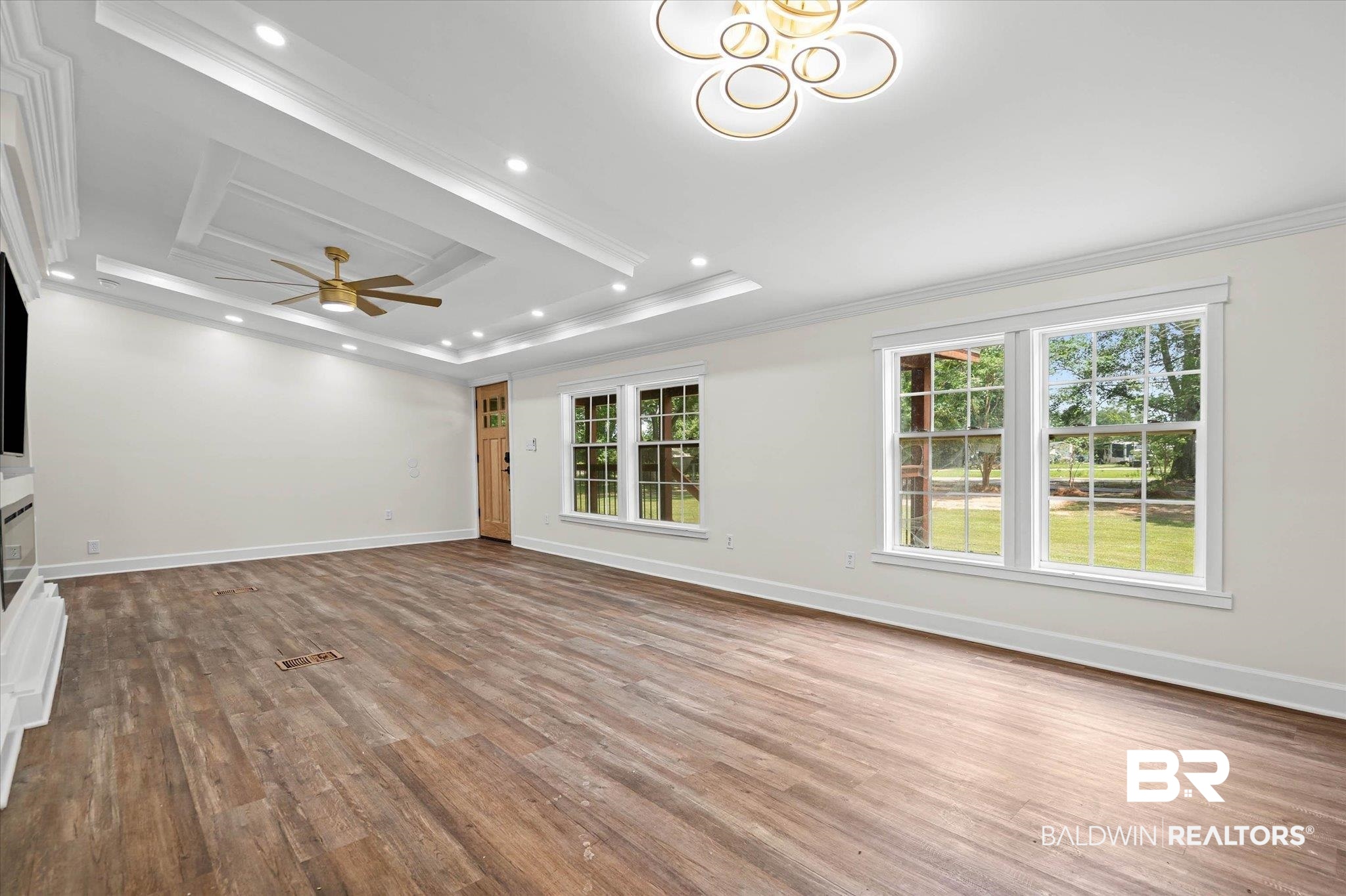 9230 McLeod Road Mobile, AL 36695 - Photo 5 of 20 Spacious interior with wood-finish flooring, recessed lighting, and a multi-tiered tray ceiling featuring a ceiling fan