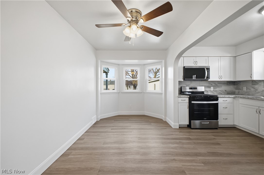 227 Wilson Street Struthers, OH 44471 - Photo 10 of 44 Kitchen with stainless steel appliances, white cabinetry, decorative backsplash, and light wood-type flooring