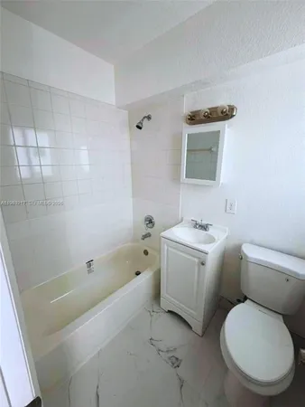 a bathroom with a sink a toilet and bathtub