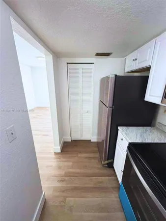 a view of walk in closet with wooden floor and cabinet