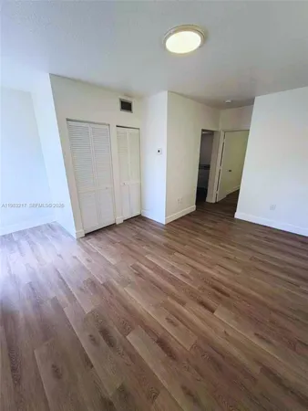 an empty room with wooden floor and closet