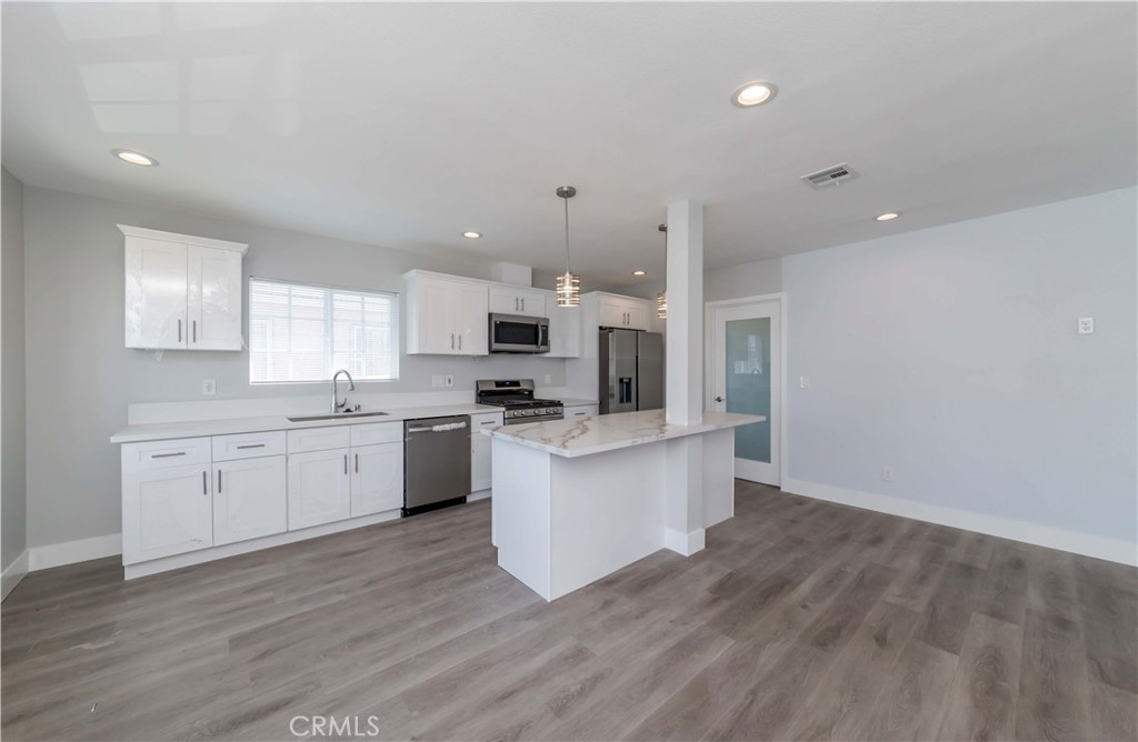 4569 Whitney Drive El Monte, CA 91731 - Photo 18 of 41 a kitchen with white cabinets stainless steel appliances and window